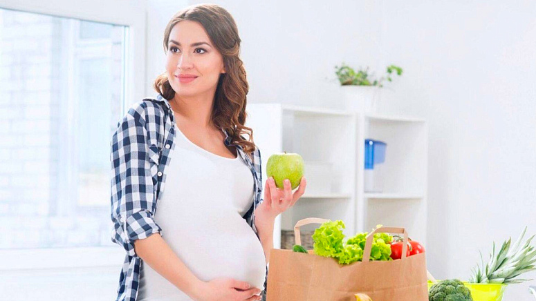 Беременная женщина и яблоко фото