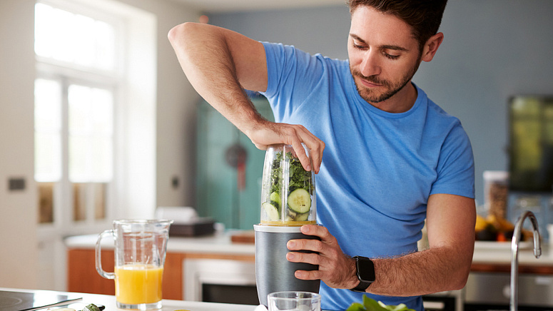 Мужчина делает себе смузи фото
