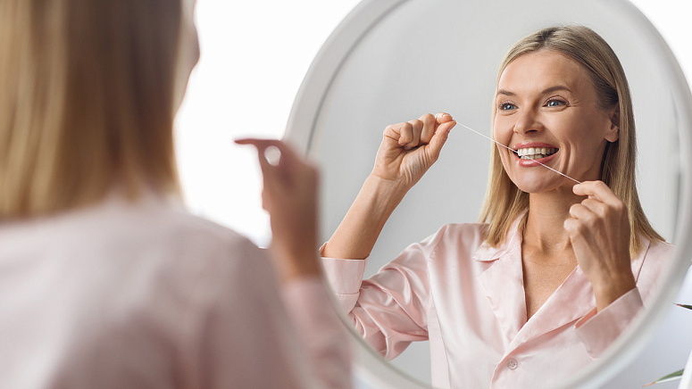 Девушка использует зубную нить фото