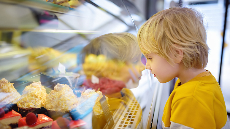 ребенок у прилавка с тортом фото